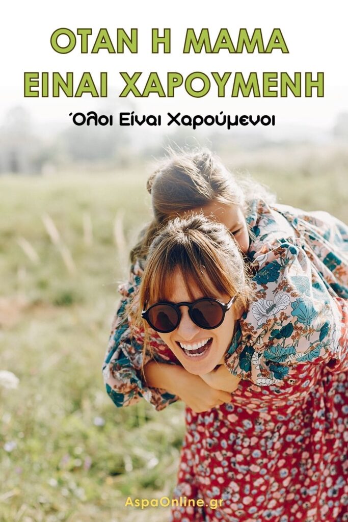 Μια χαρούμενη μαμά με γυαλιά ηλίου και πολύχρωμο φόρεμα γελάει καθώς κουβαλάει την κόρη της στην πλάτη, σε ένα καταπράσινο λιβάδι. Το κείμενο γράφει: "Όταν η μαμά είναι χαρούμενη, όλοι είναι χαρούμενοι". Εικόνα από το AspaOnline.gr.